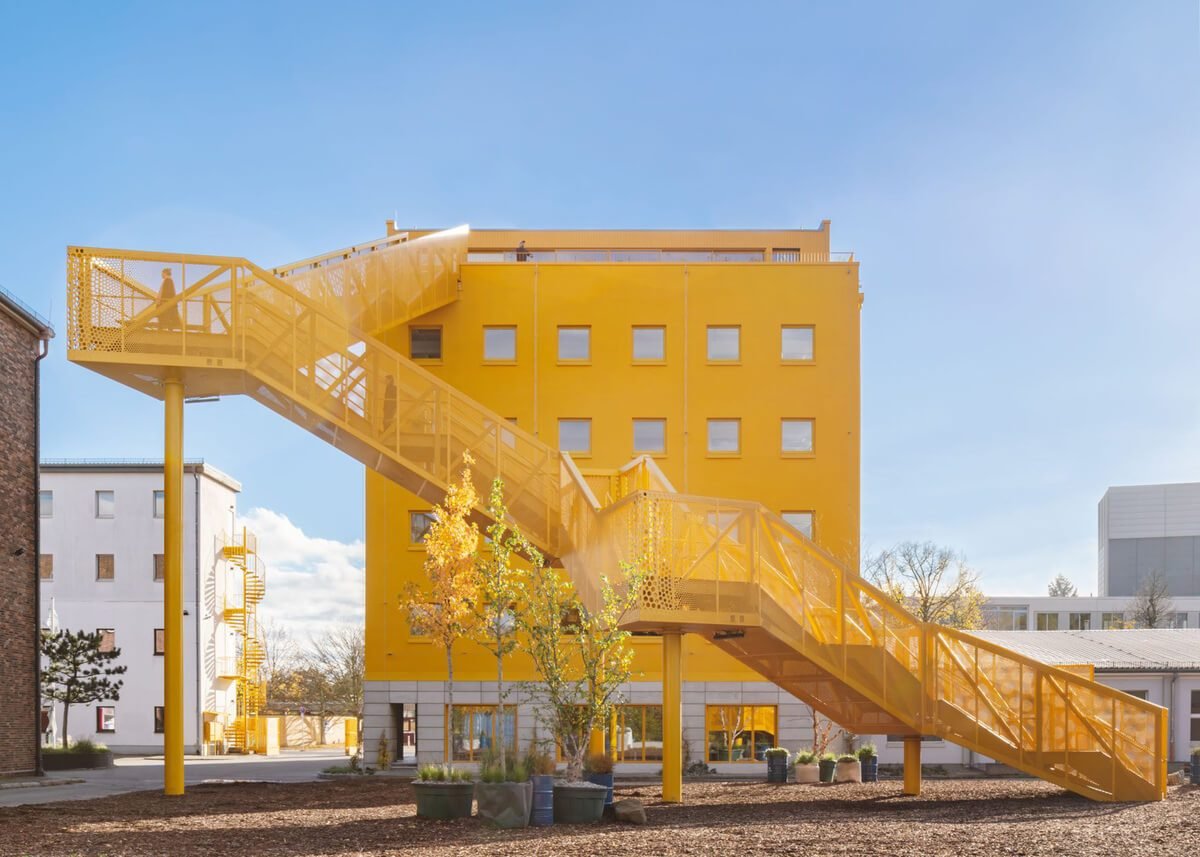 Gelbe skulpturale Außentreppe an Haus 1 der Atelier Gardens in Berlin Tempelhof